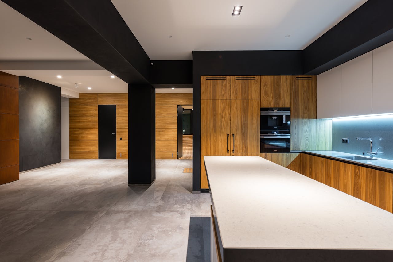 expertise-01 Sleek contemporary kitchen interior with wooden cabinets and minimalist style.